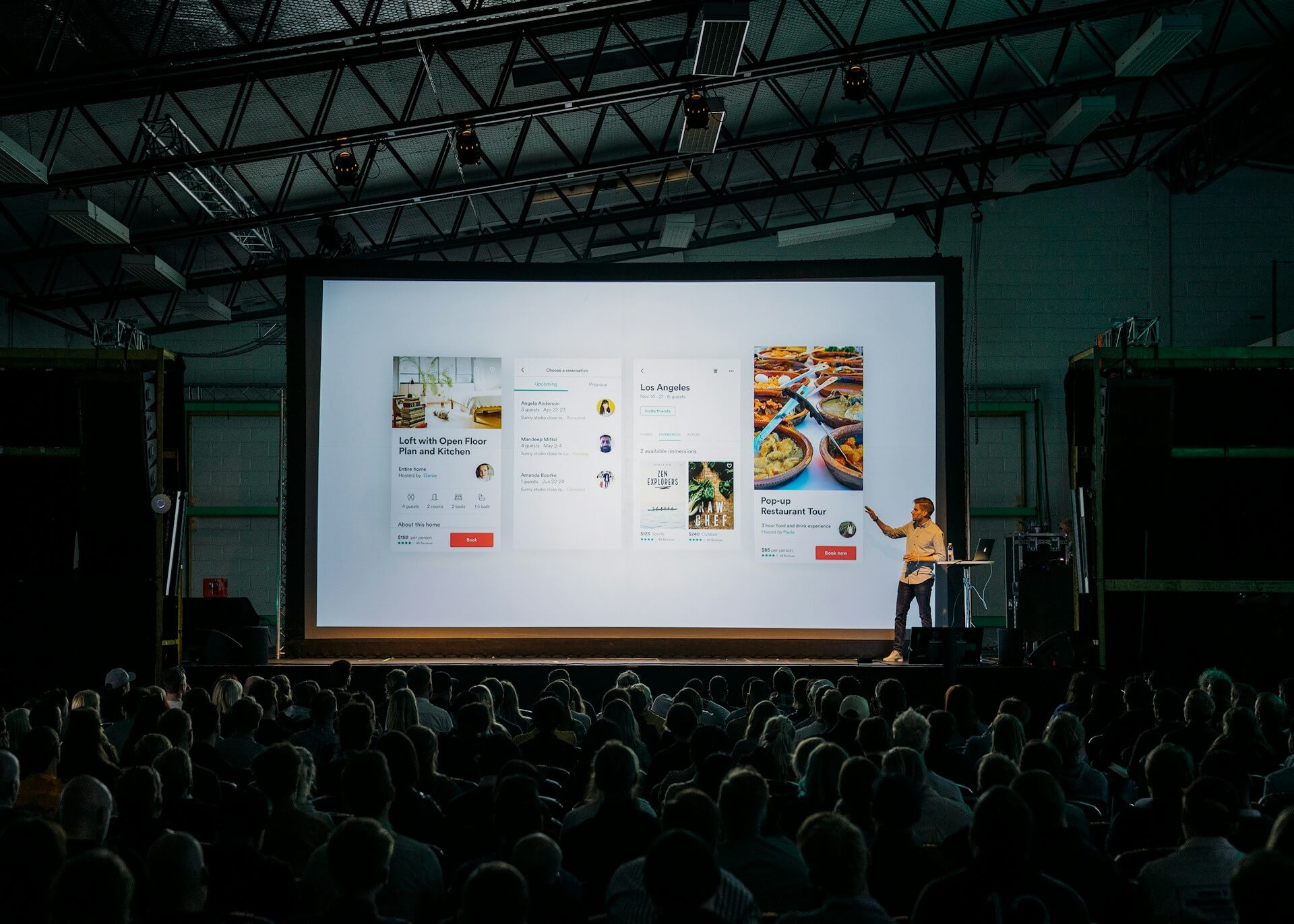 Conference with presenter presenting in front of a large screen
